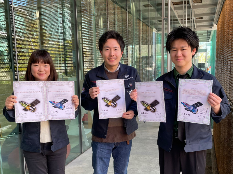 JAXA XRISMチームから表彰を受けた信川講師（左）、伊藤さん（中央）、青木さん（右）
