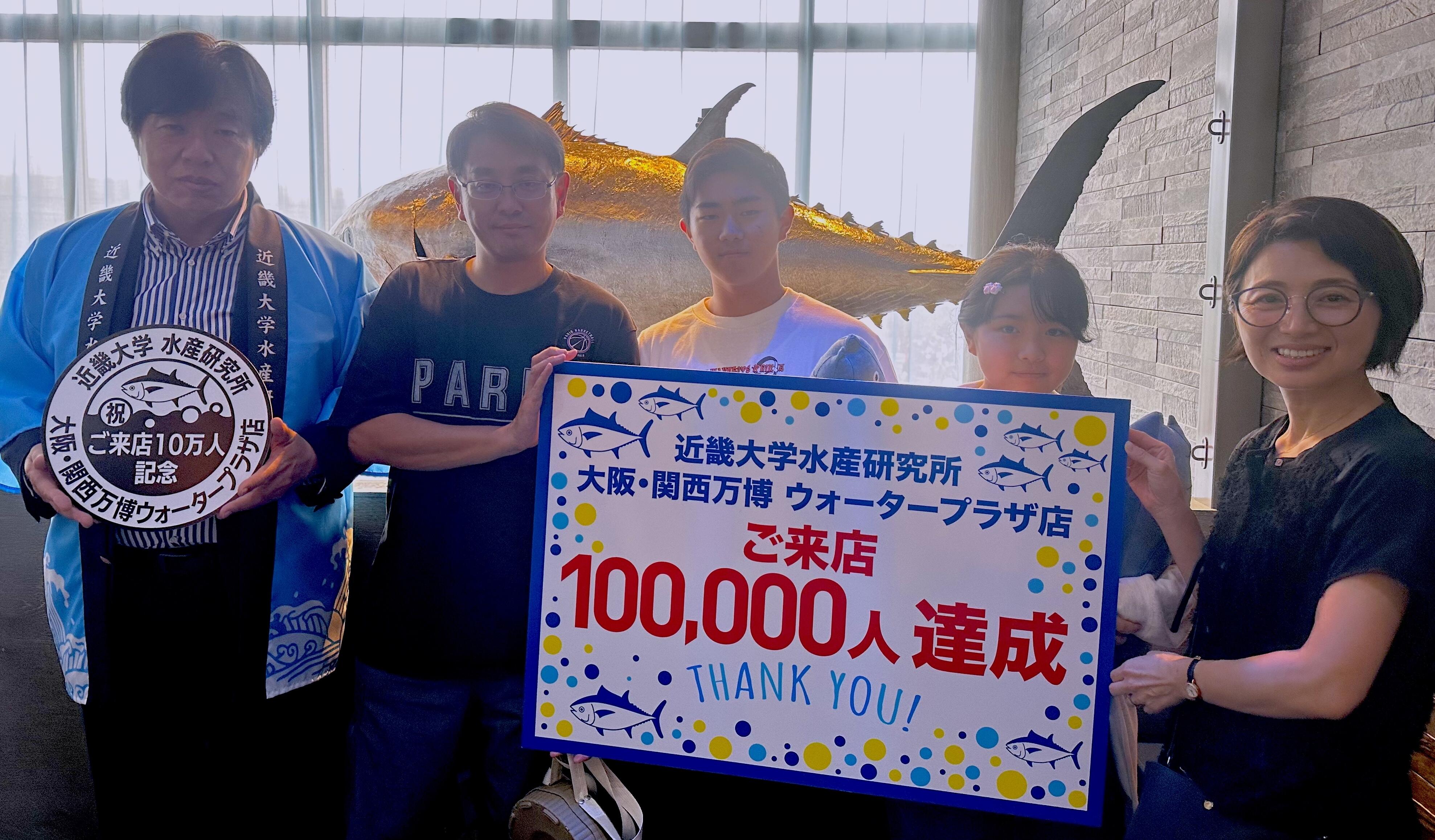 「近大卒の魚と紀州の恵み 近畿大学水産研究所 大阪・関西万博 ウォータープラザ店」の累計来店者10万⼈を達成！店舗に10万⼈達成を記念したオリジナルスタンプも設置