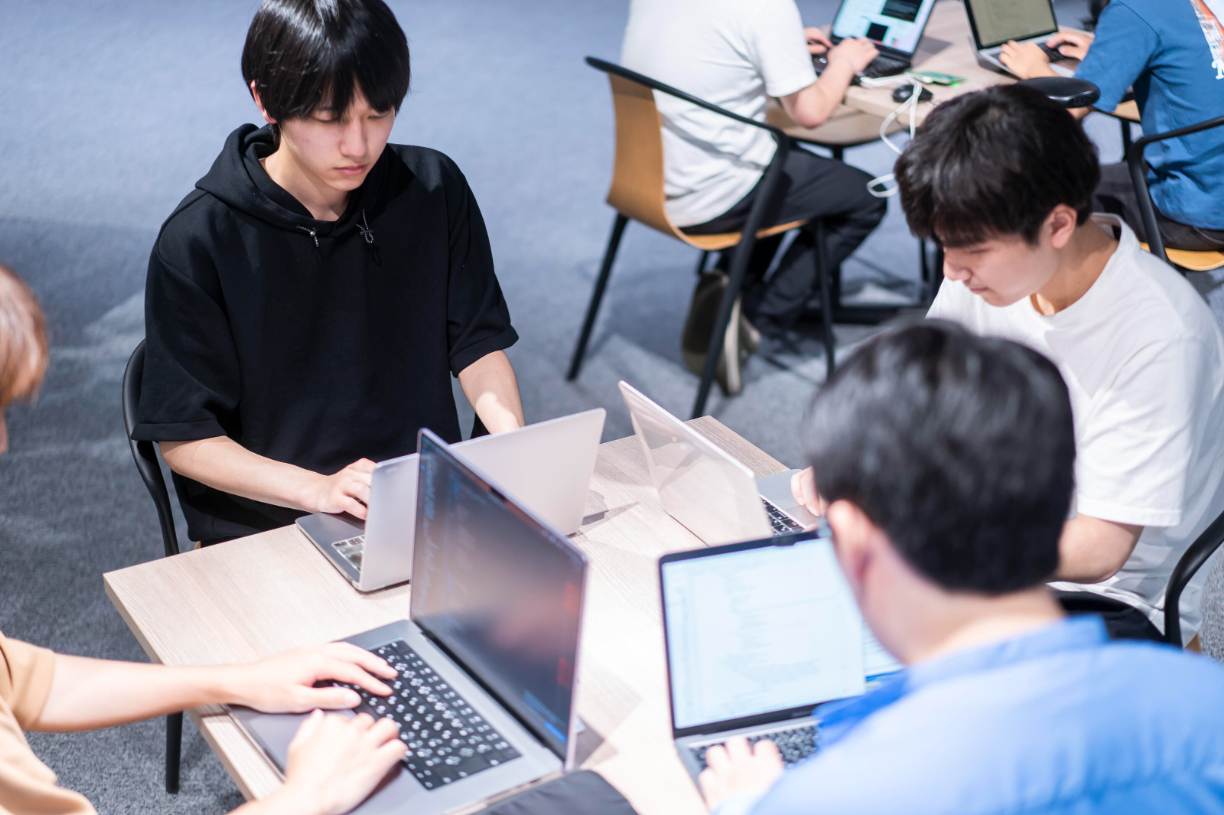 プログラミングBootCampの様子。数人のグループでノートパソコンに向かう学生たち